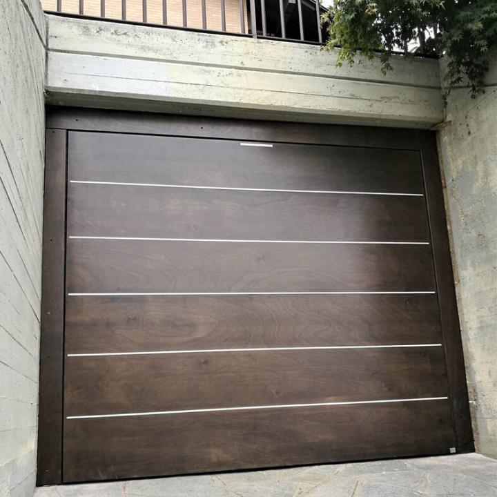 Installazione di SecureMe, porta basculante di sicurezza per garage numero uno in Italia, in multistrato marino, legno, con inserti in alluminio. Stile moderno