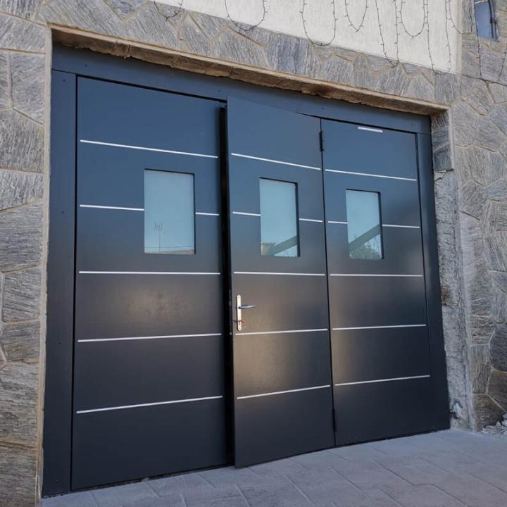 Installazione di SecureMe, porta basculante di sicurezza per garage in multistrato marino, legno, dotata di oblò e portina pedonale. Nero grigio